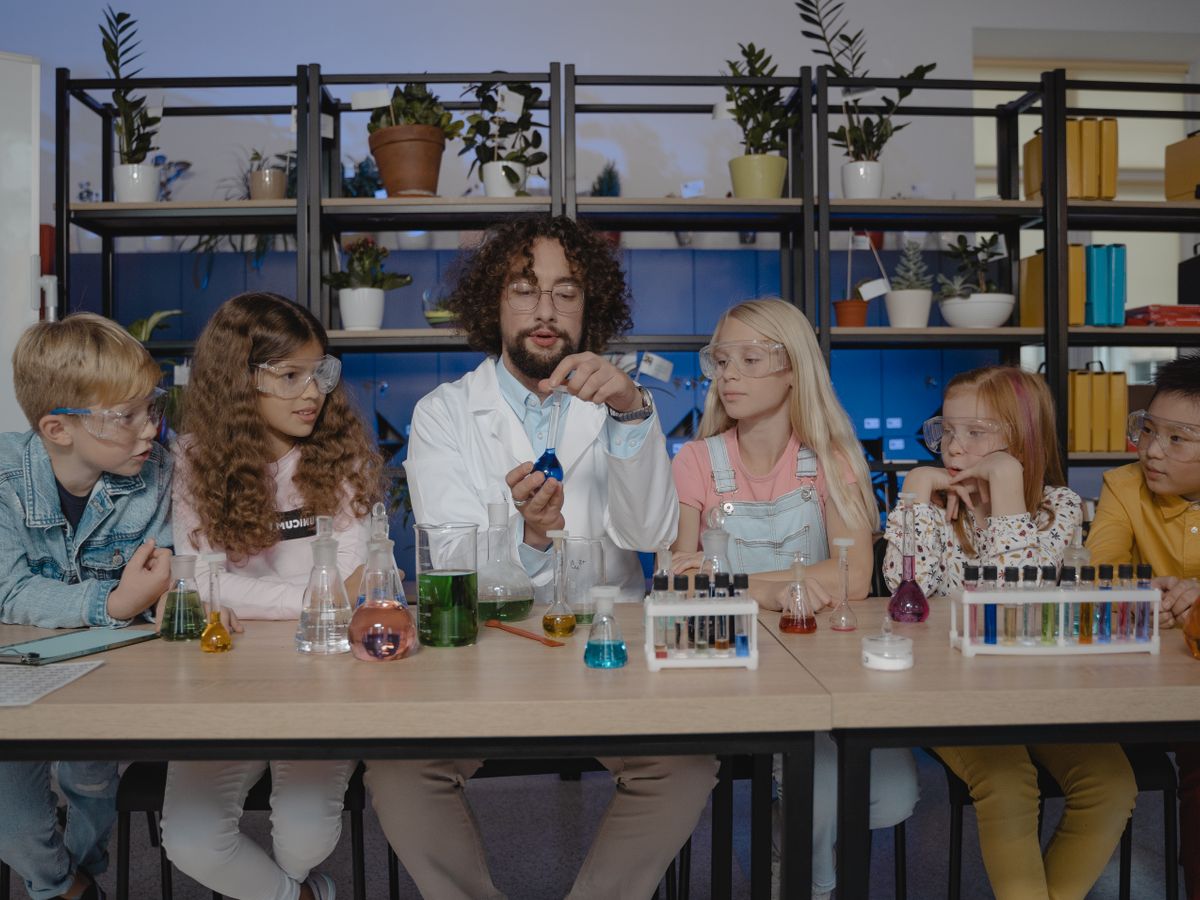 A teacher demonstrating a science experiment to students in a laboratory